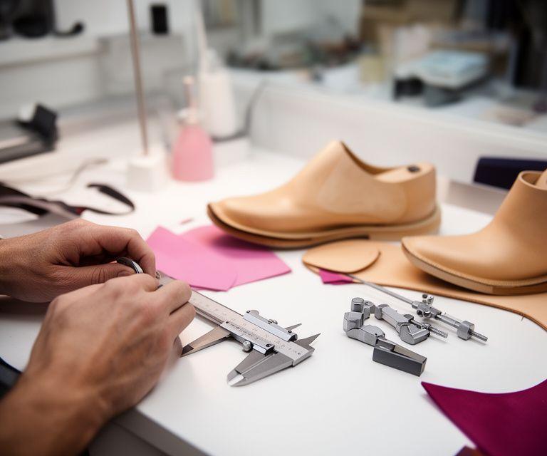 Orthopädische Massschuhe in einer hellen Zürcher Werkstatt mit Messwerkzeugen und Lederproben